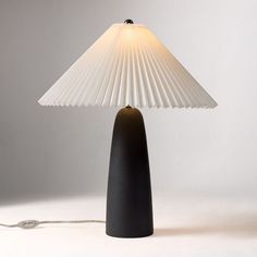 a lamp that is on top of a white table cloth with a cord attached to it