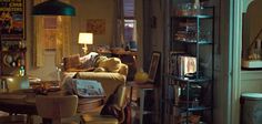 a living room filled with furniture next to a tall book shelf covered in lots of books