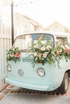 an old vw bus decorated with flowers and greenery