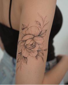 a woman's arm with a flower tattoo on it