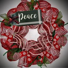 a red mesh wreath with peace written on it