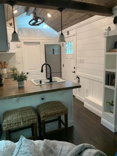 a kitchen with two stools in front of the sink