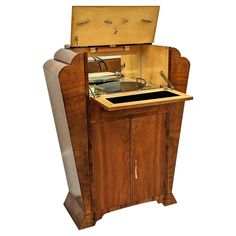 an old fashioned record player in a wooden cabinet with its doors open and the lid opened