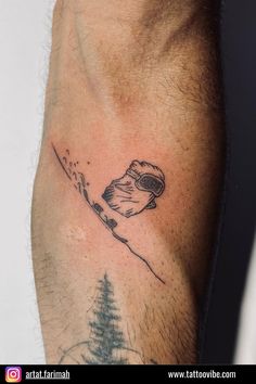 a man's arm with a tattoo of a snowboarder and trees on it