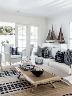 a living room filled with white furniture and pillows