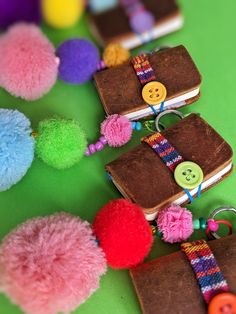 several small notebooks with pom - poms attached to them