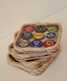 four coasters are stacked on top of each other with different colored beer bottle caps