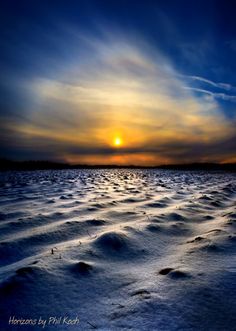 the sun is setting over an ocean covered in snow