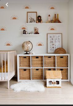 a baby's room with white walls and wooden drawers