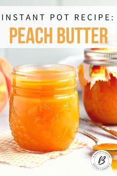 two jars filled with peach butter sitting on top of a table next to spoons