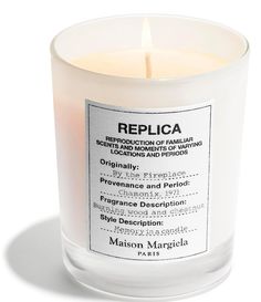 a white candle that is sitting on a table with the label replicaa printed on it