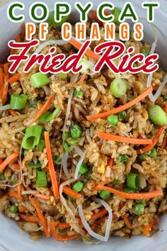 a white bowl filled with fried rice and veggies on top of a table