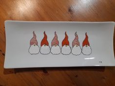 a white plate with four gnomes painted on it