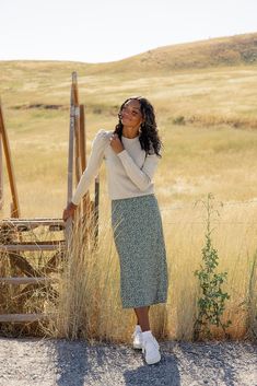 Adorned with dainty florals, this skirt brings a touch of feminine charm to any occasion. Whether you're dressing up for a special night out or keeping it casual, this skirt's timeless cut and pattern makes for the perfect style companion. slight high-low elastic waist unlined black // paired with the miles city sweater sienna // paired with the lancaster pocket sweater in ivory darkseagreen // paired with the fortnight sweater vest steelblue // paired with the patti button tank Black Button Down Skirt Outfits, Cream Maxi Skirt Outfit, Sweater Skirt Outfit Fall, Long Skirt With Sweater, Skirt And Sneakers Outfit, Modest Chic Outfits, Black Skirt Outfit Winter, Skirt And Sweater Outfit, Midi Skirt Outfit Winter