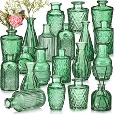 many green glass vases and one pink flower are in front of each other on a white background