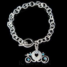 a silver bracelet with a heart and two blue stones in the center on a black background