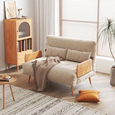 a living room with a couch, table and potted plant on the floor next to it