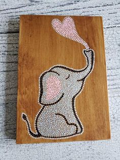 an elephant painted on wood with pink hearts