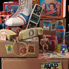 an assortment of toys and other items sitting on top of a cardboard box in front of a black background