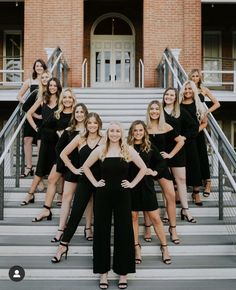 a group of women in black dresses standing on steps with their arms around each other