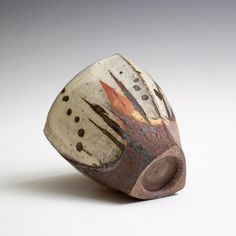 a white and brown vase sitting on top of a table