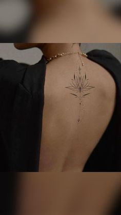 the back of a woman's neck with a flower tattoo on it