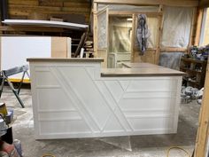 an unfinished kitchen counter in the process of being painted with white paint and wood trim