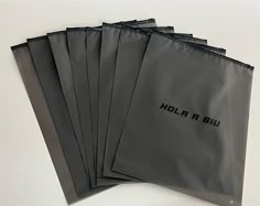 six black bags with the word hola blj on them sitting next to each other