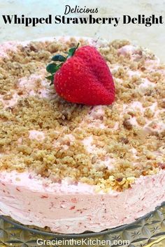 a close up of a cake on a glass plate with a strawberries topping and the words whipped strawberry delight