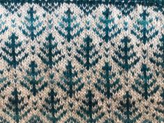 a close up view of a blue and white knitted blanket