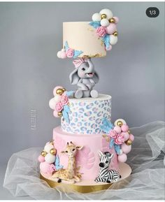 a three tiered cake with an elephant and giraffe on top