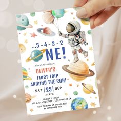 a person holding up a birthday card with an image of an astronaut on the outer planets