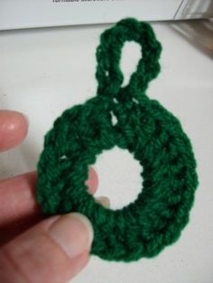 someone is crocheting a green loop together