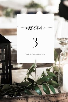 the table numbers were placed on top of each other, with candles and greenery