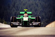 a man driving a green race car down a road