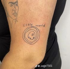 a woman with a tattoo on her arm saying it's little world and an image of elvis presley