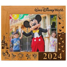 a wooden frame with mickey mouse and two children in front of the disney world character