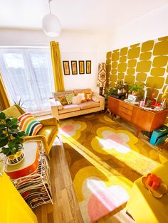 a living room filled with yellow furniture and decor on top of a hard wood floor