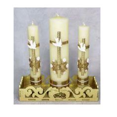 three candles are sitting on a stand with gold trimmings and bows around them