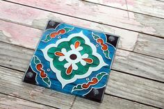 a colorful tile on top of a wooden table