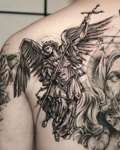 the back of a man's shoulder with an angel and demon tattoo on it