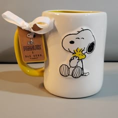 a coffee mug with a cartoon character painted on it and a tag hanging from the handle