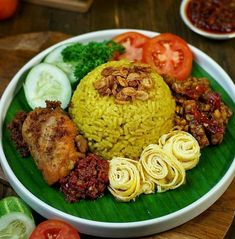 a white plate topped with rice, meat and veggies