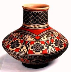 a vase with designs on it sitting on a white tableclothed surface in front of a white background