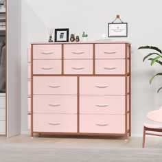 a pink dresser sitting next to a white chair