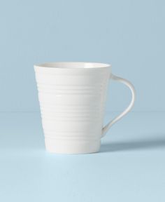 a white cup sitting on top of a blue table