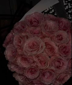 a bouquet of pink roses sitting on top of a table