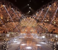 an elaborately decorated hall with chandeliers and chairs is lit up at night