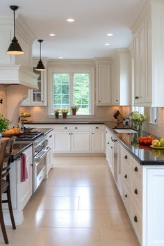 a kitchen filled with lots of white cabinets and counter top space next to a dining room table