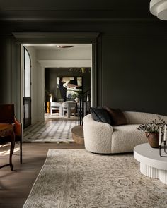 a living room filled with furniture and a rug on top of a hard wood floor